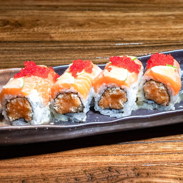 Four Kiwami Ramen Sushi rolls with salmon, cucumber, and red caviar on a dark plate.